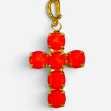 Cross charm featuring bold opaque orange crystal stones.