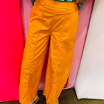 Orange wide leg washed denim pants with tulip hem and elastic waistband.