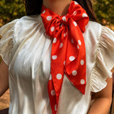 Orange and white silky polka dot scarf with versatile styling options.