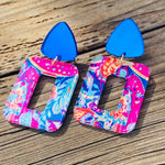 Cobalt stud earrings with pink-and-blue tropical geometric acrylic drops, lightweight and hypoallergenic.