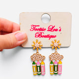 Pearl cloud earrings with dangling yellow, green, and pink pencils and floral studs.