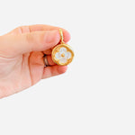 Gold mother-of-pearl floral charm with open circle frame, bead center, and lobster clasp for scarves.