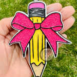 Pencil and bow car freshie with hook and string hanging from rearview mirror.
