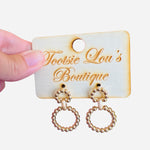 A pair of gold earrings, each featuring two interlinked hoops. Both hoops are adorned with a detailed, textured beaded pattern.