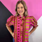 Pink mixed print blouse with ruffled neckline, button front, and smocked short puff sleeves.
