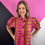 Pink mixed print blouse with ruffled neckline, button front, and smocked short puff sleeves.