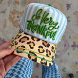 Blue striped hat with green So Very Thankful embroidery, leopard bill, and gold piping.