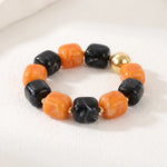 Chunky Halloween bracelet with orange and black beads and polished gold-tone accents.