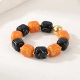 Chunky Halloween bracelet with orange and black beads and polished gold-tone accents.
