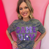 Purple Game Day tee with patchwork appliqué lettering and mixed purple print details.