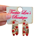 Chunky clear acrylic hoop earrings with glossy red beads and thin gold wire frame.