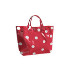 Red tote bag with oversized white polka dots and sturdy top handles.