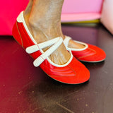 Red Mary Jane flats with double strap design.