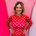 Red mesh top with white polka dots and mock neckline.