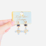 Elegant rhinestone earrings with round, rectangular, and snowflake-inspired design with square and pearl rhinestones.