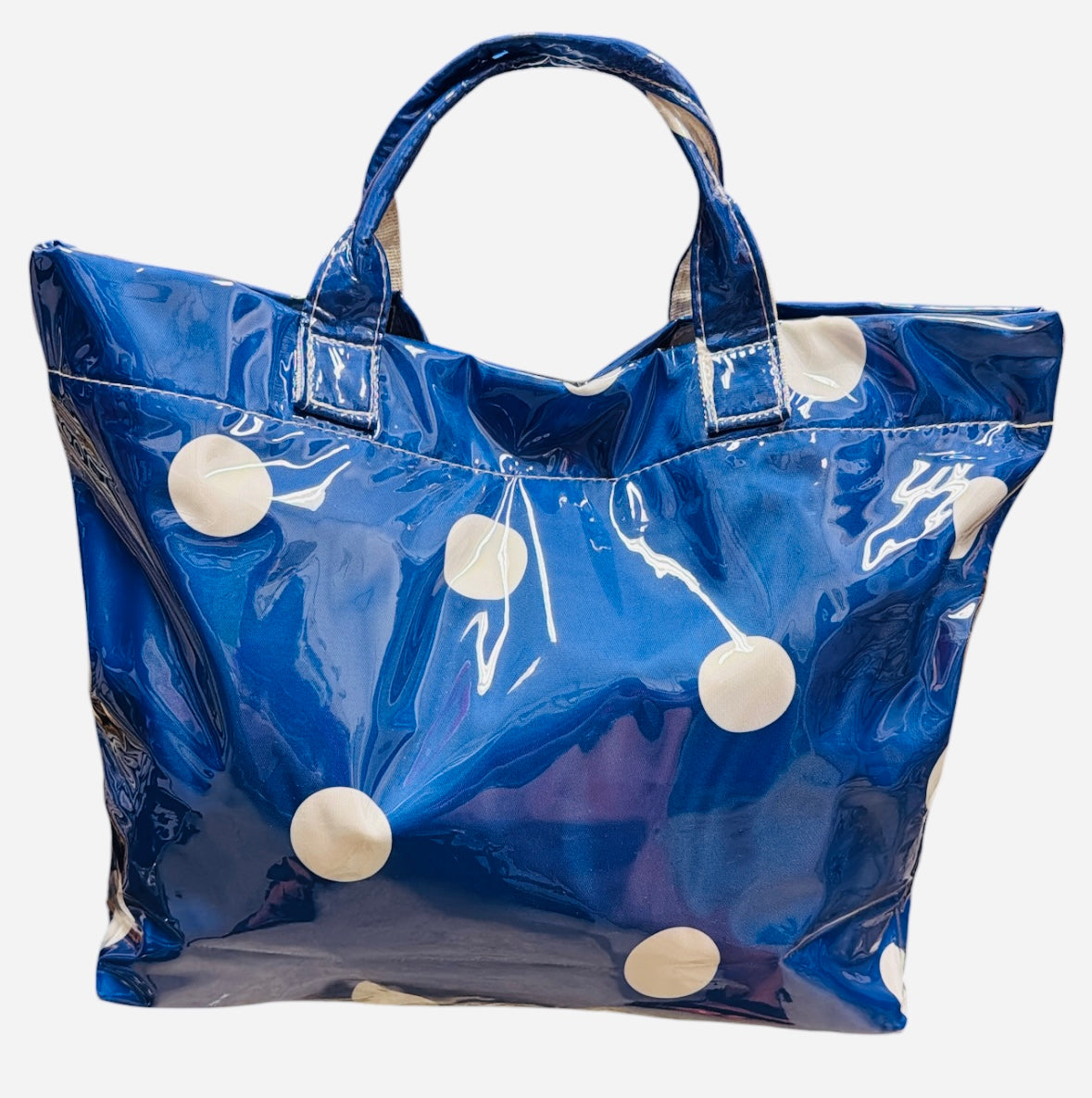 Royal blue polka dot tote bag with shiny finish and white dots.