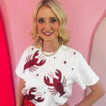White top with red sequin lobster and red rhinestone accents on stretchy fabric.