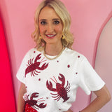 White top with red sequin lobster and red rhinestone accents on stretchy fabric.
