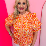 Tangerine leopard print puff sleeve top with ruffle collar and button front