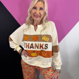 Fall pullover with embroidered pumpkins and shimmering sequin accents.