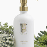 White glass hand lotion bottle with gold pump in Joshua Tree scent.