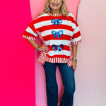 Patriotic striped top with oversized blue sequin bows and relaxed fit.