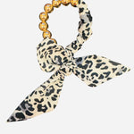 White and black animal print scarf bracelet with oversized gold water-resistant beads.