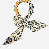 White and black animal print scarf bracelet with oversized gold water-resistant beads.