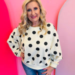 White sweatshirt with bold black polka dots and relaxed dropped-shoulder fit.