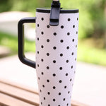 White 40oz tumbler with black polka dots, flip straw lid, and handle.