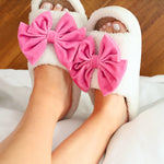White and pink cozy bow open-toe house slippers.