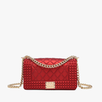 Wine quilted vegan leather crossbody bag with gold chain strap and studded detailing.