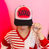Black trucker hat with white front panel and bold red XOXO Valentine design