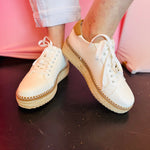 Ivory espadrille sneaker with jute flatform sole, tan heel detail, and lace-up design.