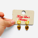 Yellow round crystal earrings with faceted amber teardrops and polished gold-tone settings.