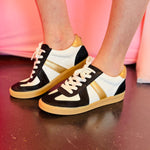 Black, white, and metallic gold lace-up sneakers with glitter accents and hidden wedge.