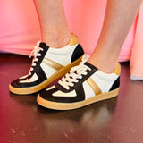 Black, white, and metallic gold lace-up sneakers with glitter accents and hidden wedge.