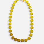 Yellow opaque crystal tennis necklace with gold-tone settings and magnetic clasp.