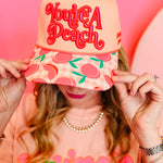 Peach canvas hat with You’re A Peach embroidery and colorful peach print brim.
