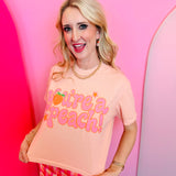 Blush pink crop tee with retro peach graphic and playful lettering on Comfort Colors shirt