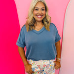 Dusty blue corded rib knit top with hi-low V-neck and short sleeves