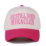 Zenana Fuchsia and white canvas cap with "He Still Does Miracles" embroidered on the front.