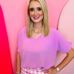 Mauve lightweight woven V-neck top with short sleeves and relaxed fit