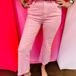 Pink cropped bootcut jeans with frayed hem and high-rise fit.
