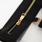 Clear crossbody bag with black trim and gold hardware, featuring a detachable sunglasses holder—fun and functional for any event.